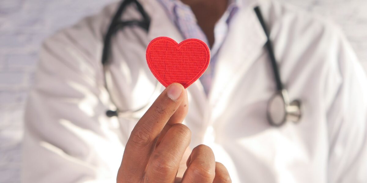 Healthcare professional holding red paper heart